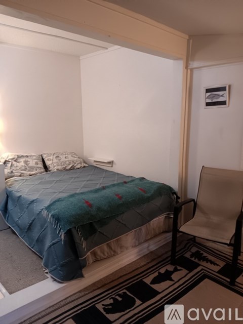 A bedroom with a bed and a chair.