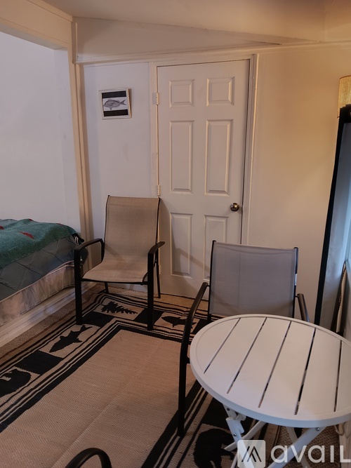A small room with a bed, chair, and table.