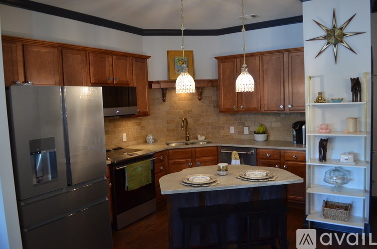 A kitchen with a refrigerator, microwave, and a table set for two.