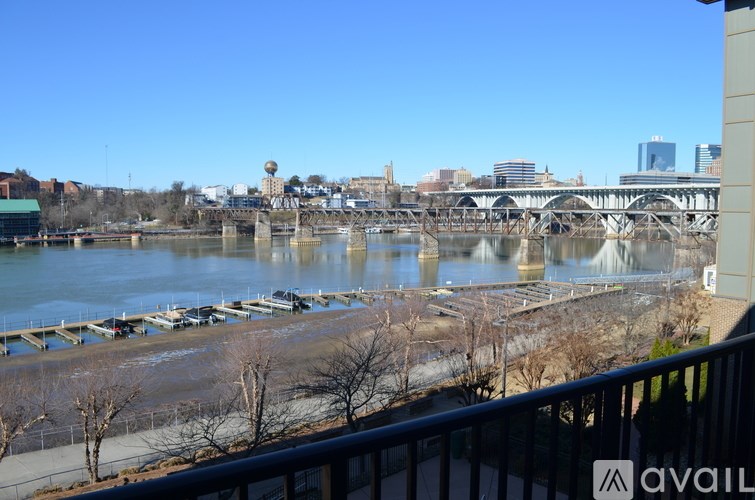 A river flows under a bridge with a city in the background.