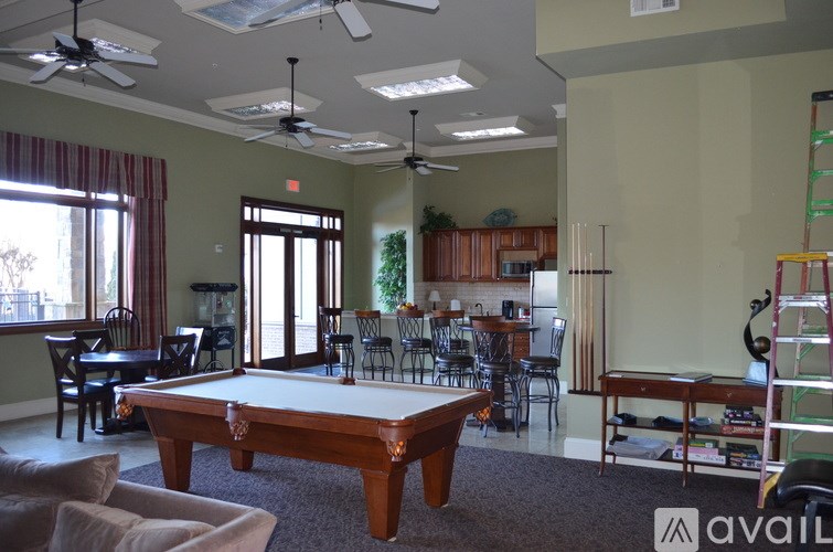 A billiard table is in the middle of a room with a pool table.