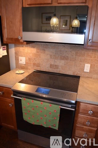 A black oven with a green towel on it.