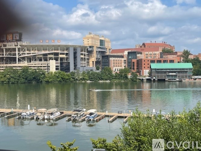 A view of a lake with boats docked at a pier and a stadium in the background.