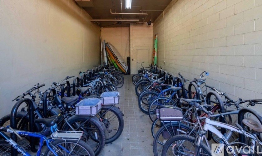 A row of bicycles are parked in a hallway.