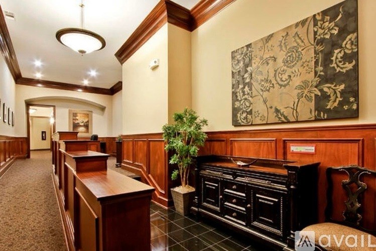 A hallway with a plant and a large picture on the wall.