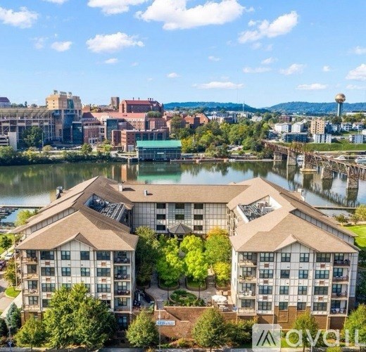 Two buildings with the logo "avail" in front of a river.