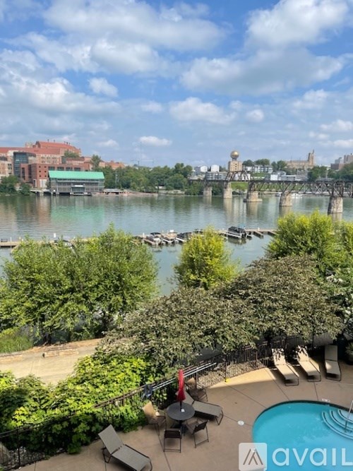 A pool area with a view of a river and a bridge.