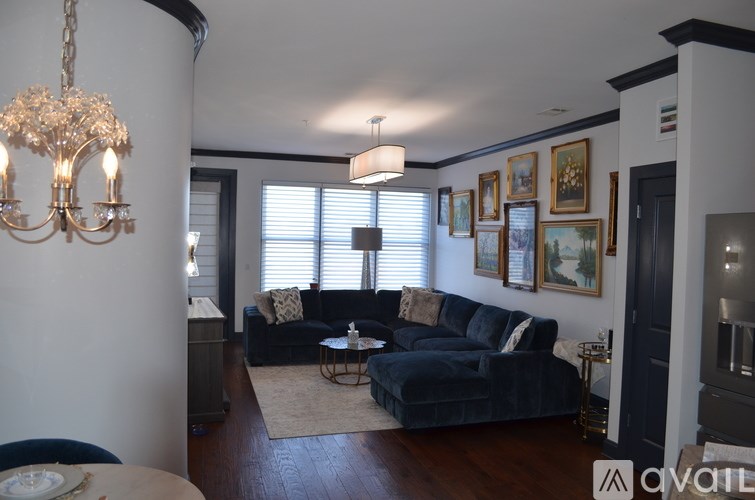 A living room with a blue couch and a chandelier.