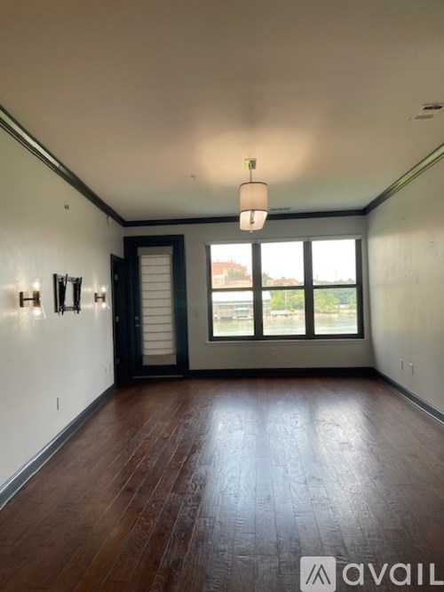 A bedroom with a white bed and a lamp on a side table.