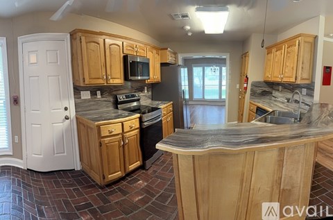 A kitchen with wooden cabinets and a stone countertop.