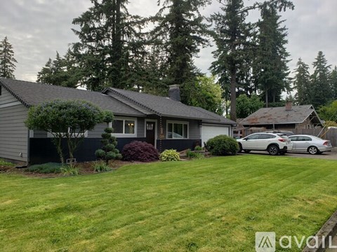 A house with a grey roof and a white car parked in front.