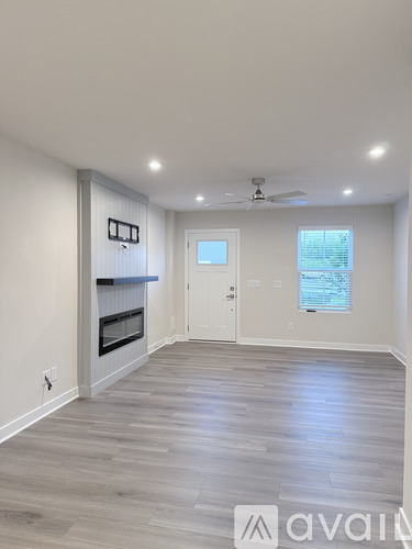 A spacious room with a fireplace and a ceiling fan.