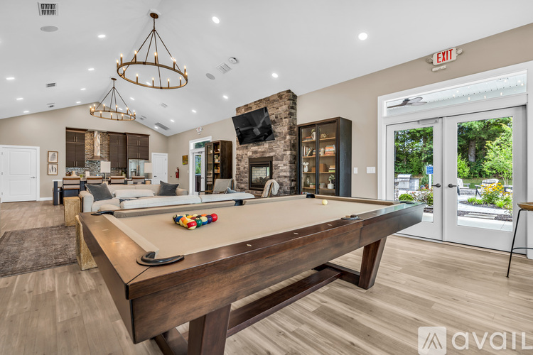 A pool table in a room with a chandelier and a fireplace.