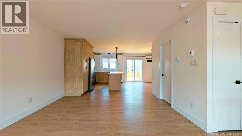 A spacious living room with wooden floors and white walls.