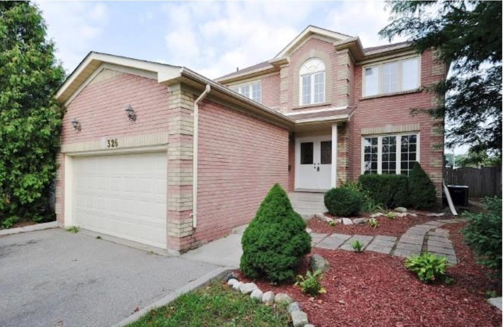 A red brick house with a white garage door.