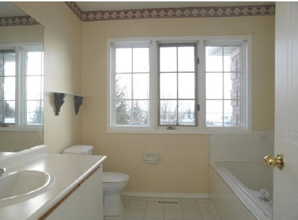 A bathroom with a toilet, sink, and bathtub.