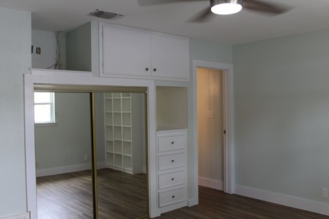 A room with a white cabinet and a ceiling fan.