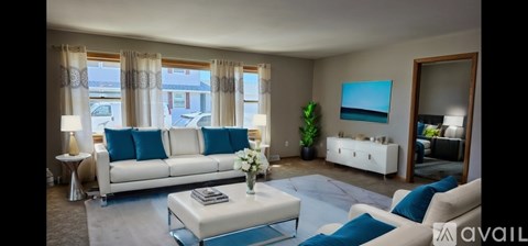 A living room with a white sofa and a coffee table.