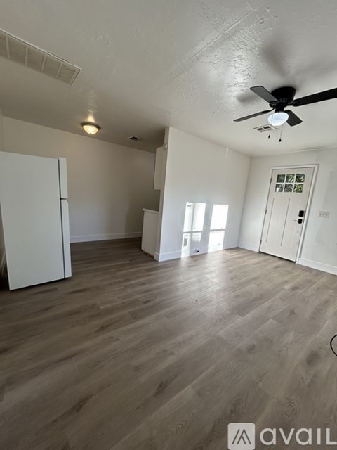 A bathroom with a white cabinet and a mirror is visible through a doorway.