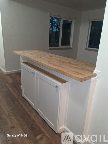 A kitchen with white cabinets and a wooden countertop.