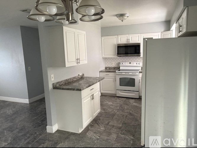 A kitchen with a white refrigerator, microwave, and oven.