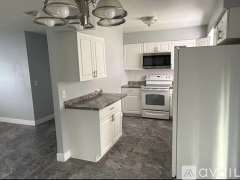 A kitchen with a white refrigerator, microwave, and oven.