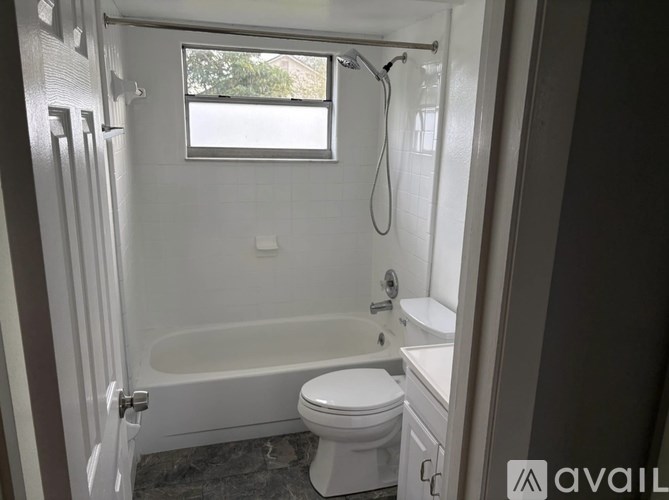 A bathroom with a toilet, sink, and bathtub.