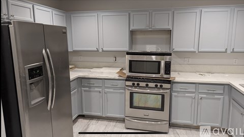 A kitchen with white cabinets and stainless steel appliances.