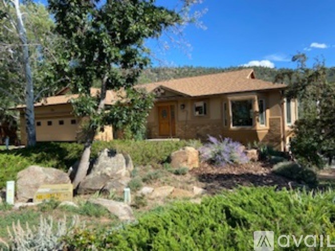A house with a brown roof and a garden in front.
