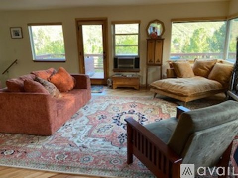 A living room with a red couch and a rug.