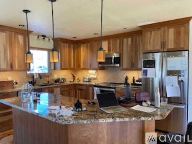 A kitchen with wooden cabinets and granite countertops.