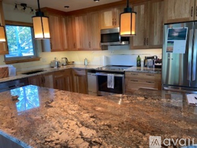 A kitchen with granite countertops and wooden cabinets.