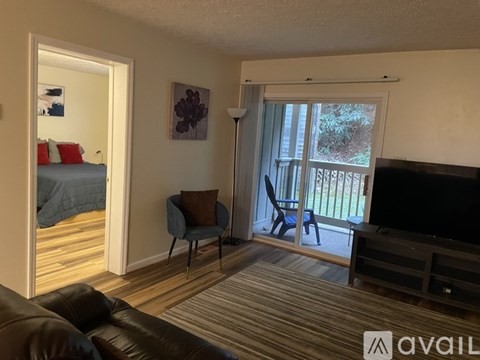 A living room with a brown leather couch and a television.