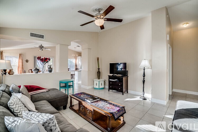A living room with a grey couch and a wooden coffee table.