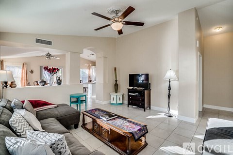 A living room with a grey couch and a wooden coffee table.