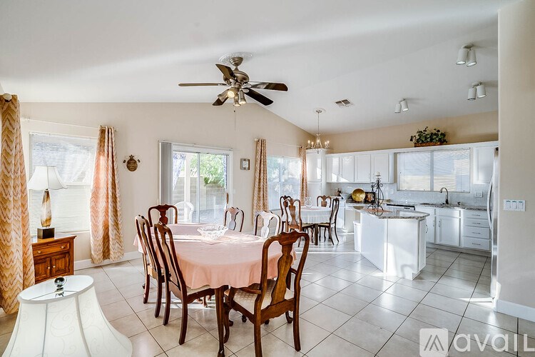 A dining room with a table set for six with a fan in the middle of the room.