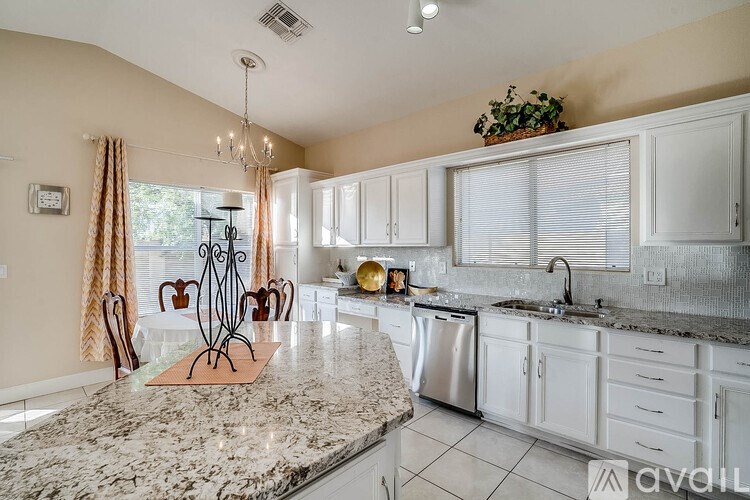 A kitchen with granite countertops and white cabinets.