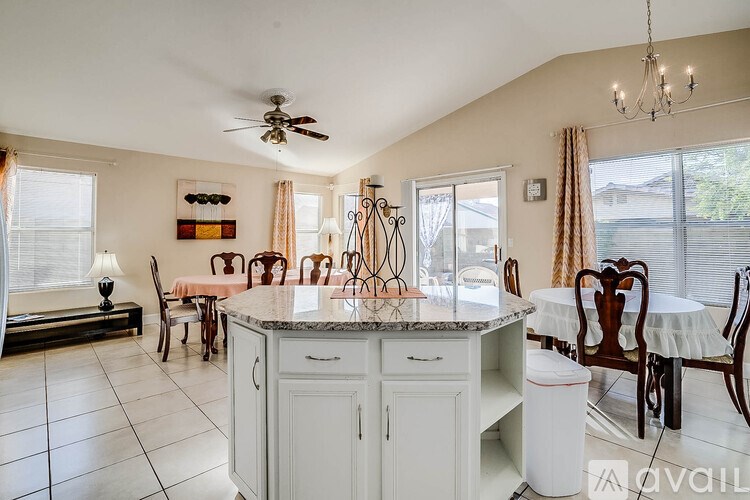 A kitchen with a table and chairs and a fan.