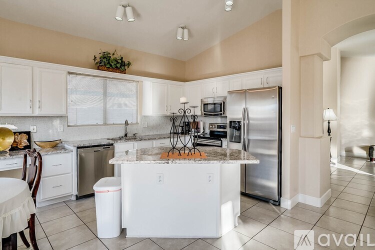 A kitchen with white appliances and a white island.