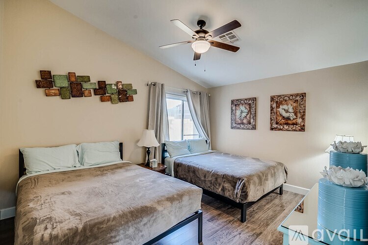 A bedroom with two beds and a ceiling fan.
