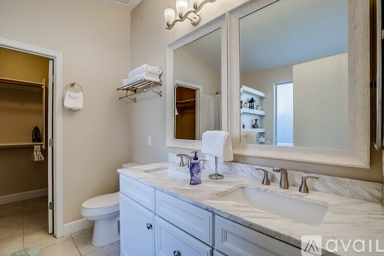 A bathroom with a white sink and a large mirror.