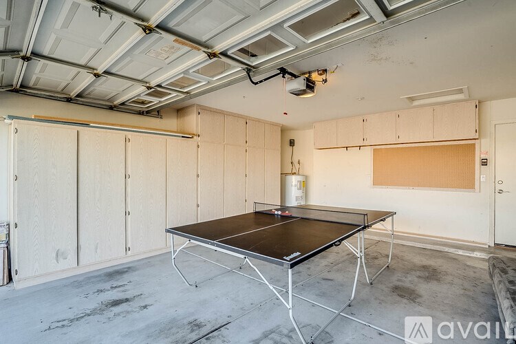 A room with a ping pong table in the middle.