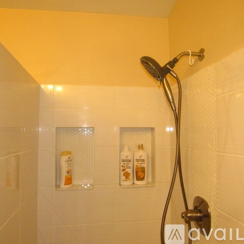 A shower area with a glass door and a shower head.