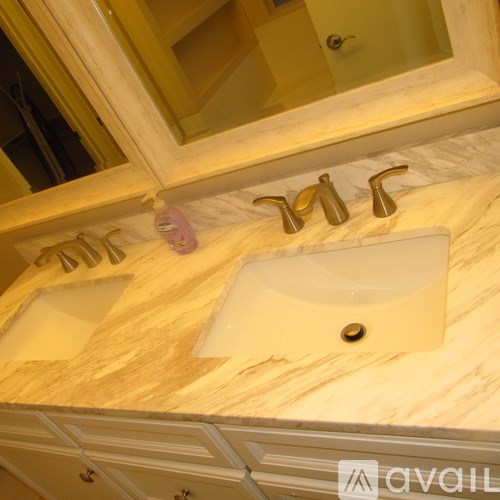 A bathroom with two sinks and a mirror above them.