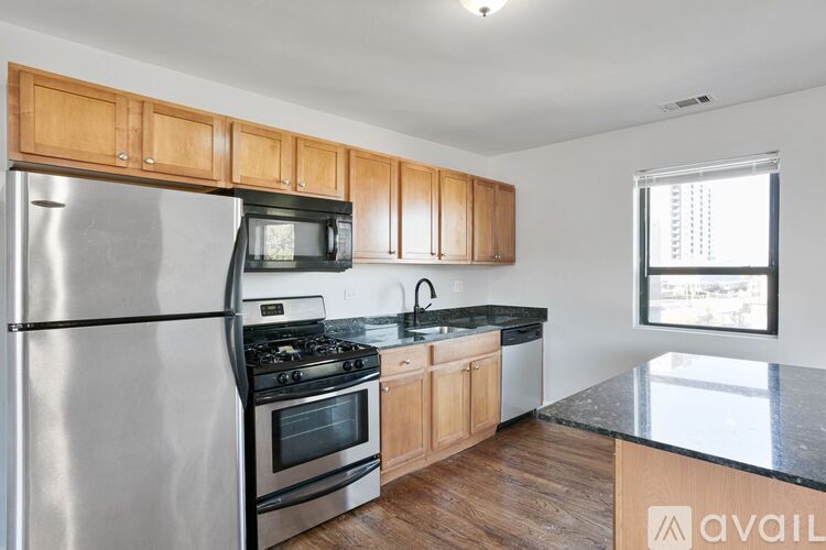 A kitchen with wooden cabinets and a stainless steel refrigerator.