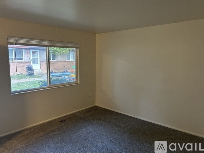 A bathroom with a white tiled shower and a wooden door.