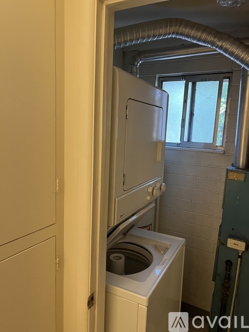 A small laundry room with a washing machine and a window.