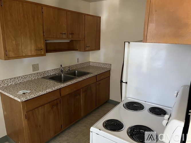 A kitchen with a white refrigerator and a granite countertop.