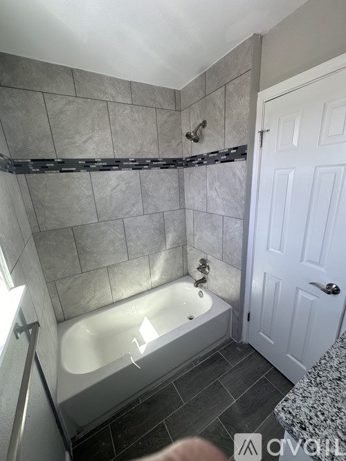 A bathroom with a tub and a door.