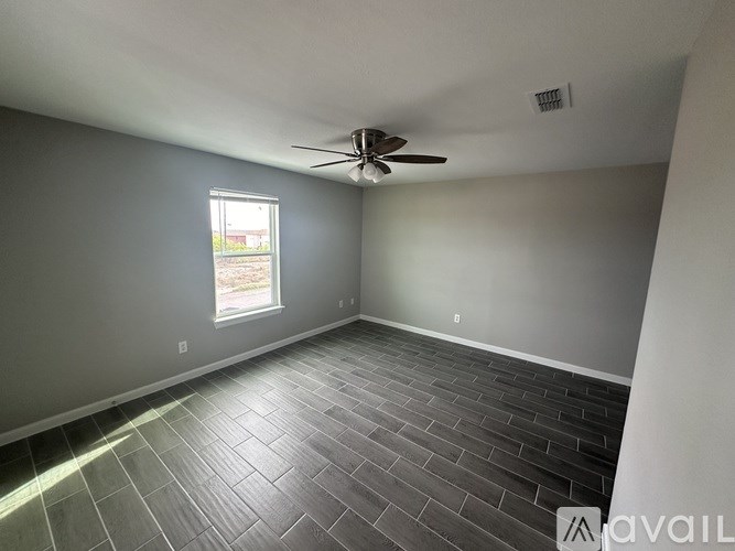 A room with a ceiling fan and a window.